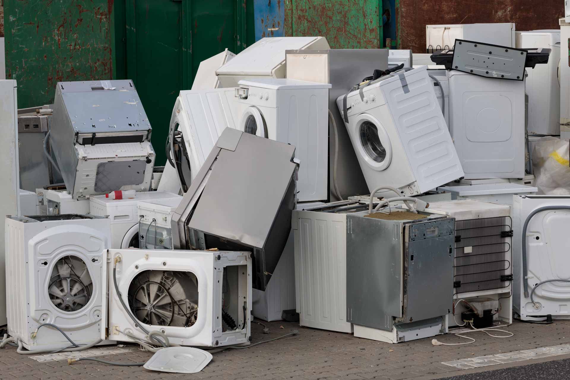 A variety of old home appliances in a heap at the dump