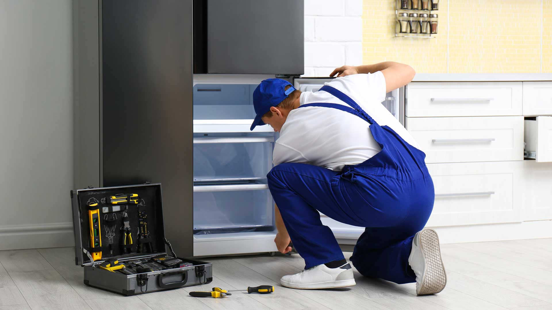 Appliance repair technician working on a refrigerator