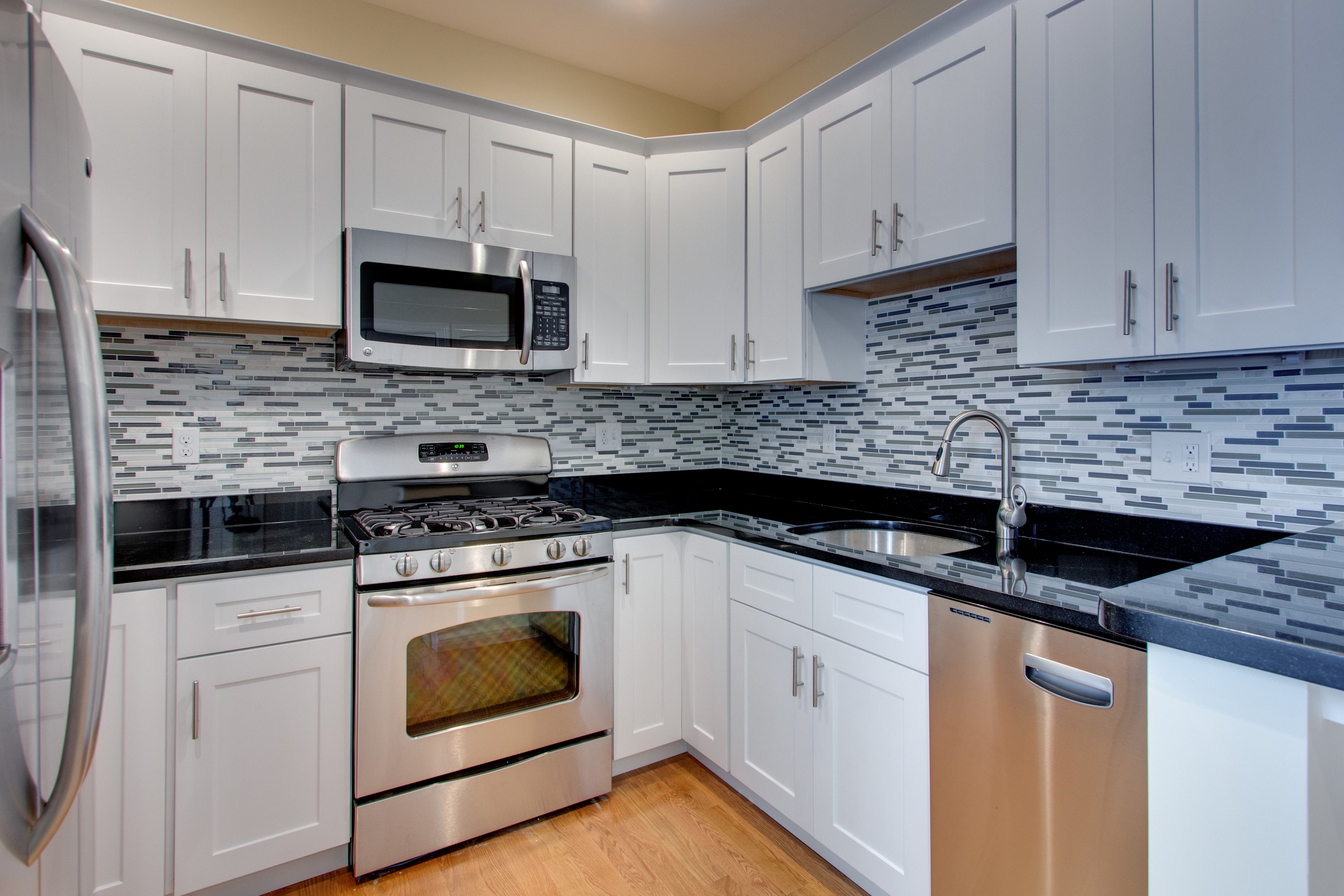 Kitchen with all stainless steel appliances: refrigerator, dishwasher, oven and microwave