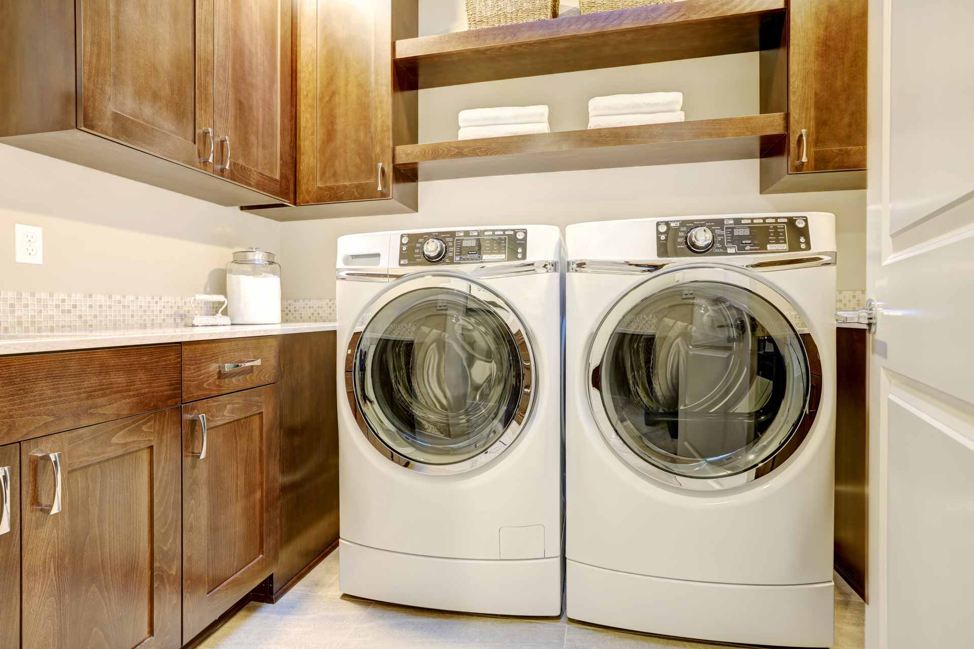 Clean, organized laundry room with matching washer/dryer set