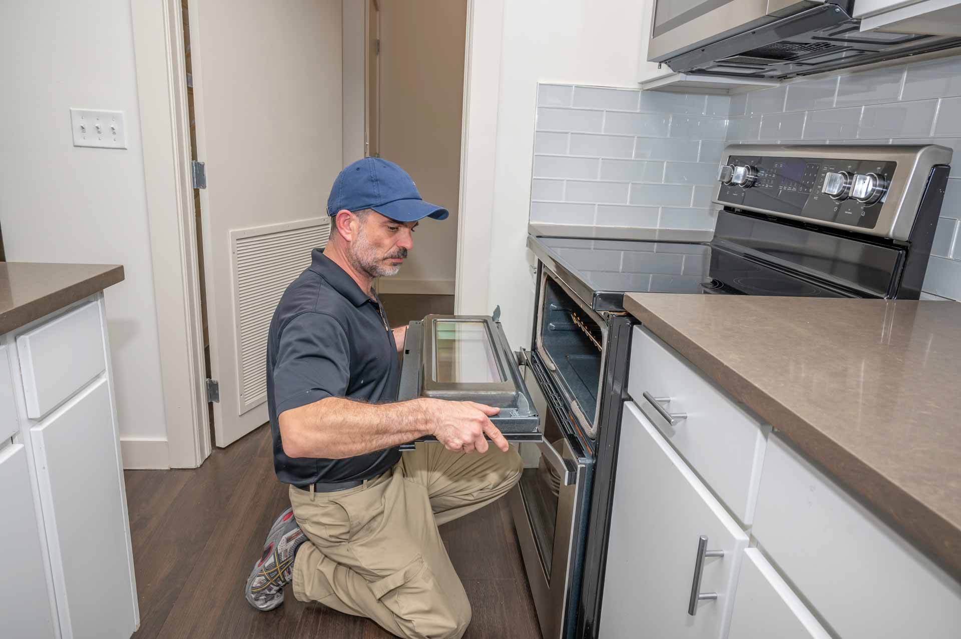 Appliance repair technician removing the door from an oven