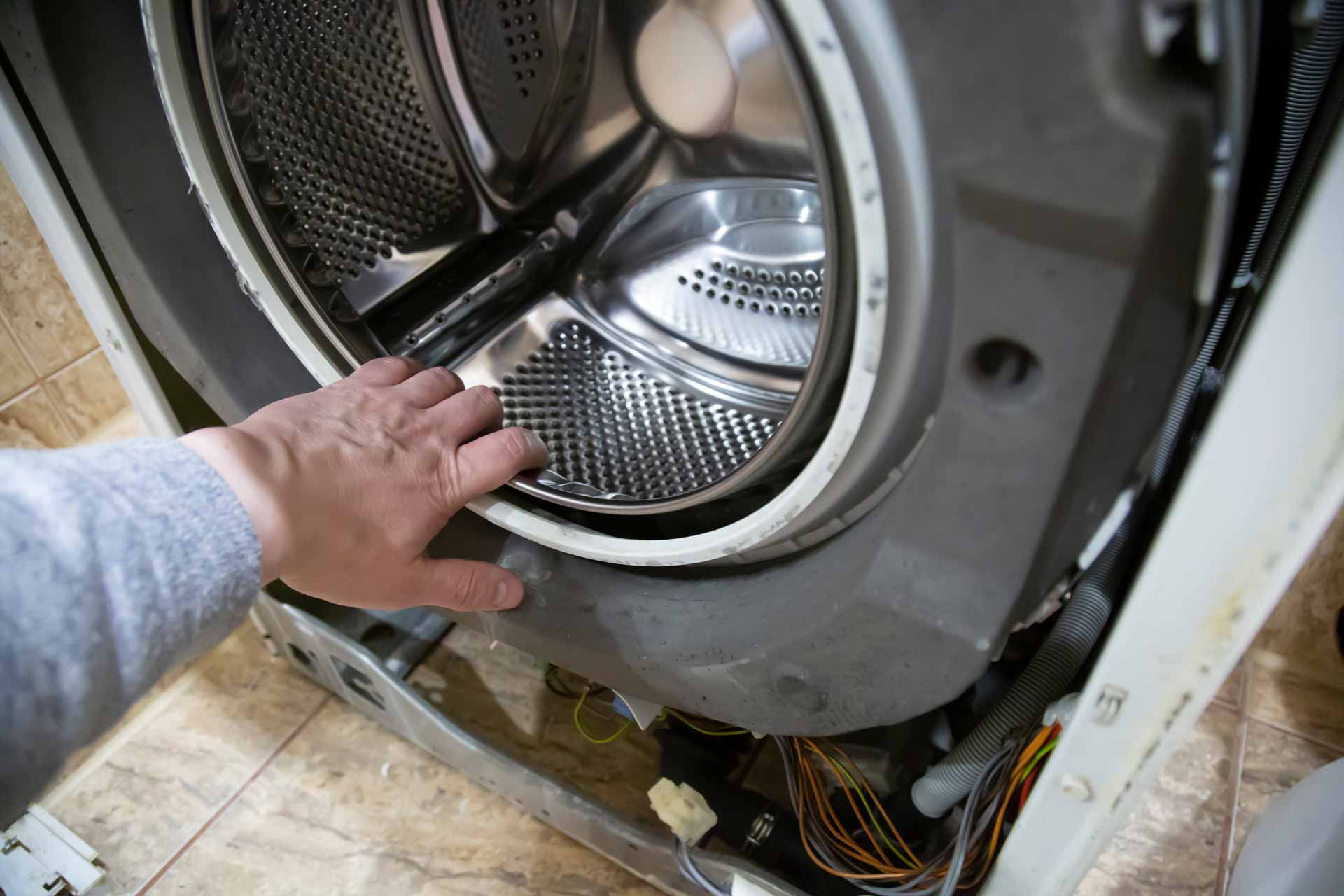 Appliance repair technician repairing a washing machine